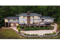 Expansive home exterior with brick accents, a multi-level deck, mature landscaping, and patio seating perfect for outdoor entertaining at 115 Forestcliff Ne Ct, Concord, NC 28025