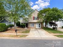 Charming two-story home with stone accents, vinyl siding, mature trees, and a long concrete driveway at 2713 Reid Meadows Dr, Charlotte, NC 28208
