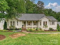 Charming single-story home with a welcoming front porch, landscaped yard, and mature trees at 3610 Mill Pond Rd, Charlotte, NC 28226