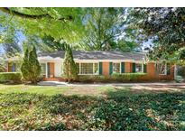 Charming brick home featuring green shutters, mature trees, and a well-maintained lawn at 415 Princeton Dr, Salisbury, NC 28144