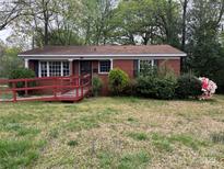 Charming single-story brick home with a cozy front porch and blossoming landscaping at 4817 Ridgeley Dr, Charlotte, NC 28208