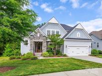Charming home with stone accents, manicured lawn, and an attached two-car garage at 5420 Meadowcroft Way, Fort Mill, SC 29708
