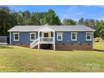 Charming blue home with a welcoming front porch and well-maintained lawn at 5528 Little Mountain Rd, Gastonia, NC 28056