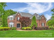 Classic brick home showcasing a manicured lawn and beautiful landscaping at 5940 Four Wood Dr, Matthews, NC 28104