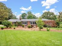 Charming brick home featuring well-maintained front yard and beautiful landscaping at 895 Furnace Rd, Iron Station, NC 28080