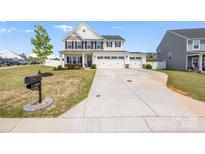Charming two-story home with a three car garage and large driveway, enhanced by a well-maintained front yard at 1636 Tundra Ln, Denver, NC 28037