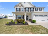 Charming two-story home featuring manicured landscaping and a welcoming front porch at 1636 Tundra Ln, Denver, NC 28037