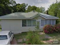 Cozy one-story home with light siding, lush landscaping, and a metal roof at 1703 Lowder St, Albemarle, NC 28001