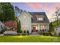 Charming home with manicured lawn, lush landscaping, and a welcoming front porch at sunset at 3101 Auburn Ave, Charlotte, NC 28209