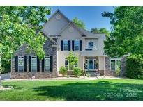Beautiful two-story home with stone accents, black shutters and lush green lawn at 397 Fischer Rd, Fort Mill, SC 29715