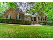 Charming brick home featuring manicured landscaping, a walkway leading to the front door, and complemented by lush greenery at 4033 Weddington Manor Ct, Matthews, NC 28104