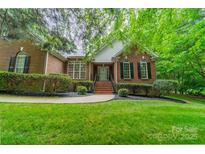 Charming brick home featuring a beautifully landscaped yard, walkway, and classic architectural details at 4033 Weddington Manor Ct, Matthews, NC 28104