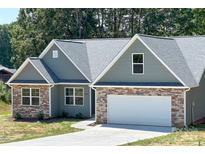 Craftsman style home with green siding, stone accents, attached two-car garage, and a concrete driveway at 4049 Fincher Rd # 3, Matthews, NC 28104