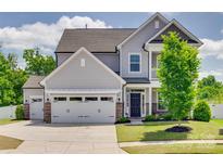 Charming two-story home with a manicured lawn, stone accents, and a two-car garage at 6176 Russo Ct, Lancaster, SC 29720