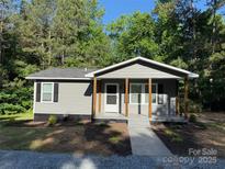 Charming gray house with wood posts supporting a porch and lush landscaping at 654 Old Nc 515 Hwy, Wadesboro, NC 28170
