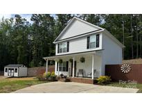 Charming two-story home featuring a cozy front porch with rocking chairs and manicured landscaping at 658 Morgan Rd, Albemarle, NC 28001