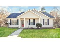 Charming home featuring well-maintained lawn, sidewalk, and classic architectural details under a bright, partly cloudy sky at 7830 Lobilia Ln, Charlotte, NC 28214