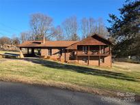 Charming brick home with a covered carport, second story balcony, and a well-maintained lawn at 1074 25Th Ne St, Hickory, NC 28601