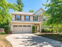 Charming two-story home featuring a two-car garage and well-manicured landscaping and brick and vinyl siding at 12304 Lookout Point Dr, Charlotte, NC 28269