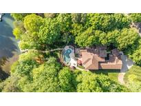Stunning aerial view of a private home nestled in lush greenery with a backyard pool and lake access at 135 Sumter Dr, Mooresville, NC 28117