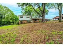 Charming split-level home with brick and siding exterior, mature trees, and a covered parking area at 1521 19Th Sw St, Hickory, NC 28602