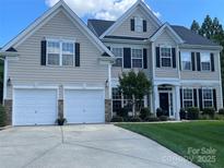 Traditional two-story home featuring a manicured lawn, two-car garage and classic architectural details at 1900 Birchbrook Ct, Harrisburg, NC 28075