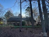 Charming single-story home with a unique roofline and inviting front entrance nestled among trees at 2 Sunrise Point Rd, Lake Wylie, SC 29710