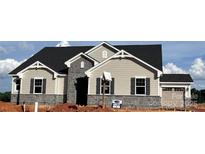 Charming new construction home featuring stone accents, black shutters, and a stylish garage door at 2512 Mabel Ln, Monroe, NC 28110