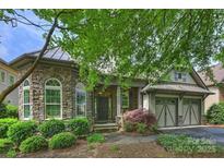 Stunning stone home featuring an arched entryway, manicured landscaping, and attached two car garage at 4122 Banfield Pl, Charlotte, NC 28226