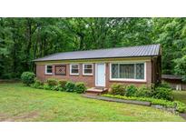 Charming brick home with metal roof, manicured landscaping, and decorative window accents at 4705 Campground View Rd, Catawba, NC 28609