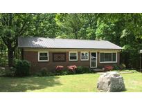 Charming brick home featuring a metal roof, well-manicured lawn, and surrounded by lush greenery at 4705 Campground View Rd, Catawba, NC 28609