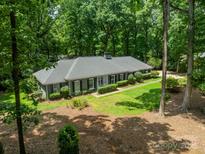 Aerial view of a charming home featuring lush landscaping, mature trees and a well-maintained lawn at 532 Courtney Ln, Matthews, NC 28105