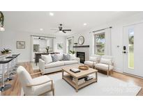 Bright living room featuring hardwood floors, a fireplace, and comfortable seating in neutral colors at 6301 Vernedale Rd, Charlotte, NC 28212