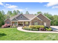 Charming brick and stone home with a manicured lawn and inviting front porch, perfect for enjoying peaceful surroundings at 730 Oak Ridge Farms Cir # 14, Newton, NC 28658