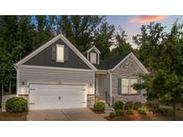 Charming home featuring a blend of stone and siding, a two-car garage, and a beautifully landscaped front yard at 7620 Porrera St, Charlotte, NC 28214