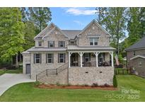Charming two-story brick home with landscaped front yard and covered front porch at 7730 Burning Ridge Dr, Stanley, NC 28164