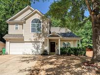 Charming two-story home with attached two-car garage, lush landscaping, and mature trees at 7923 Shiny Meadow Ln, Charlotte, NC 28215