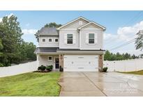Charming two-story home with a spacious driveway and attached two-car garage at 104 Trellis Ln, Troutman, NC 28166