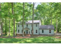 Charming two-story home with a well-maintained lawn and mature trees offering shade and curb appeal at 10501 Stonemede Ln, Matthews, NC 28105