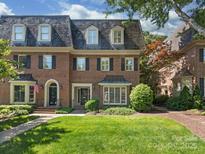 Stately brick home featuring a well-manicured lawn and classic architectural details at 232 Perrin Pl, Charlotte, NC 28207