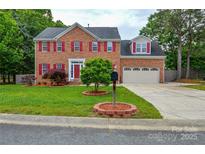 Charming brick home featuring red shutters, a well-manicured lawn, and a two-car garage at 3602 Brookstone Trl, Indian Trail, NC 28079