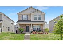Beautiful two-story home with a brick facade, landscaped front yard, and welcoming entrance at 363 Cedar Knoll Cir, Pineville, NC 28134