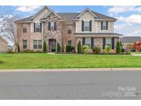 Beautiful two-story home featuring a brick and stone facade, manicured lawn, and well-maintained landscaping at 4071 Thames Cir, Fort Mill, SC 29715