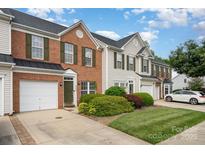 Charming townhome showcasing a brick facade, green shutters, and a well-manicured lawn at 4208 Carl Parmer Dr, Harrisburg, NC 28075