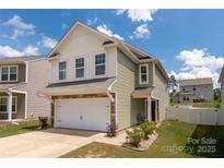 Two-story home boasts manicured lawn, attached garage, and a welcoming entrance at 507 Newfound Hollow Dr, Charlotte, NC 28214