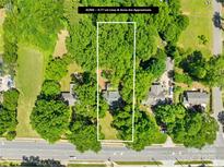 An aerial view of a wooded lot with approximate property lines and houses nearby at 6012 Tuckaseegee Rd, Charlotte, NC 28208