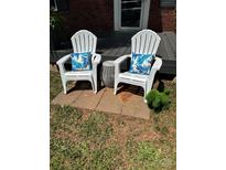Relax on the front porch with stylish Adirondack chairs and decorative pillows at 6012 Tuckaseegee Rd, Charlotte, NC 28208