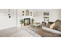 Inviting living room with fireplace, plants, neutral tones, and plush rug for a comfortable ambiance at 6012 Tuckaseegee Rd, Charlotte, NC 28208