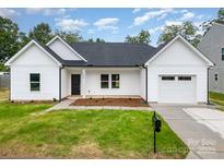 Charming, newly constructed single-Gathering home features a manicured lawn and an attached garage at 722 English St, Monroe, NC 28110