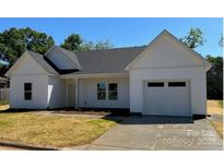 Charming one-story home with white siding, an attached garage, and a well-manicured lawn at 722 English St, Monroe, NC 28110
